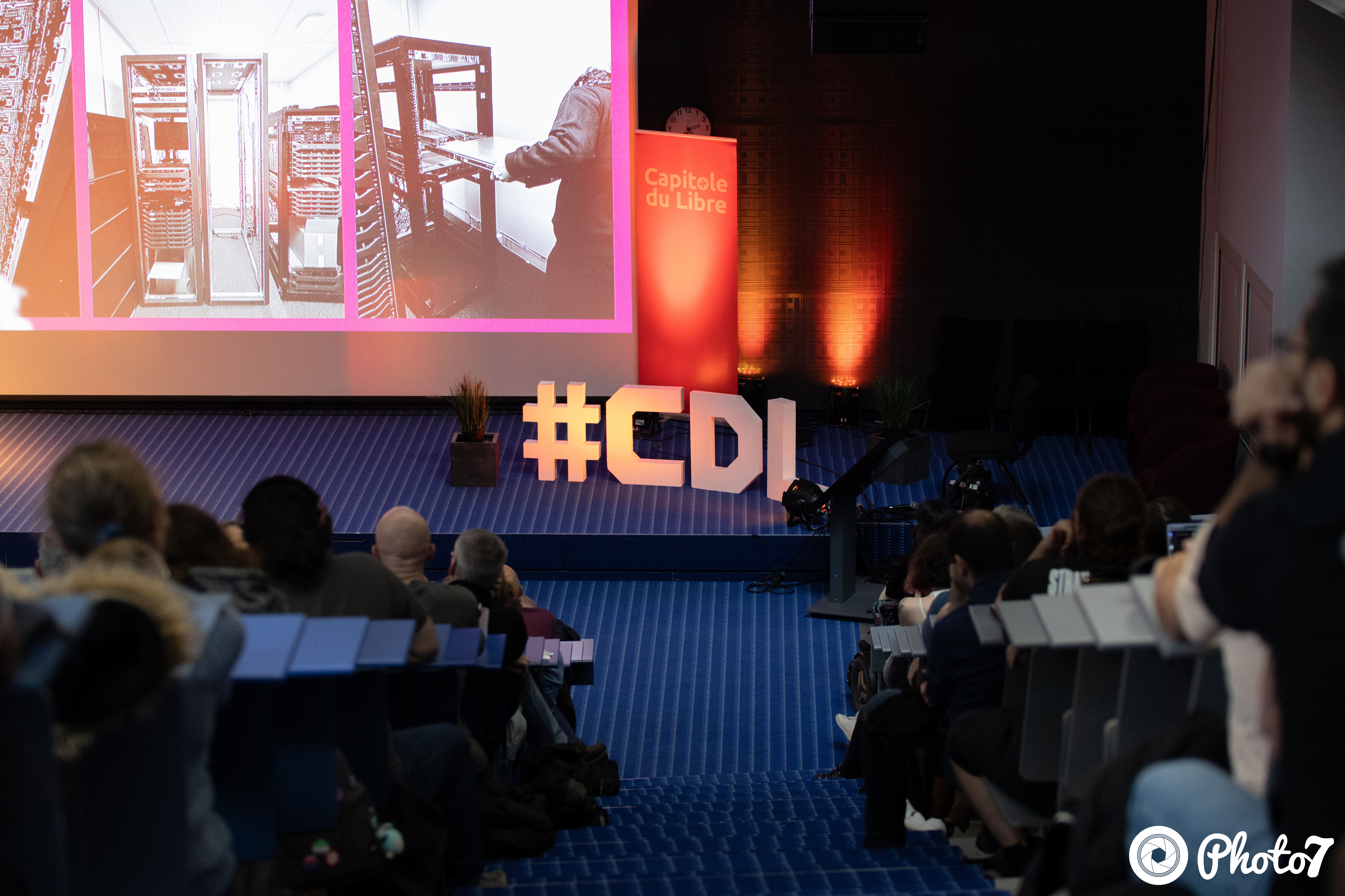 Salle de conférence vue de côté avec projection et audience