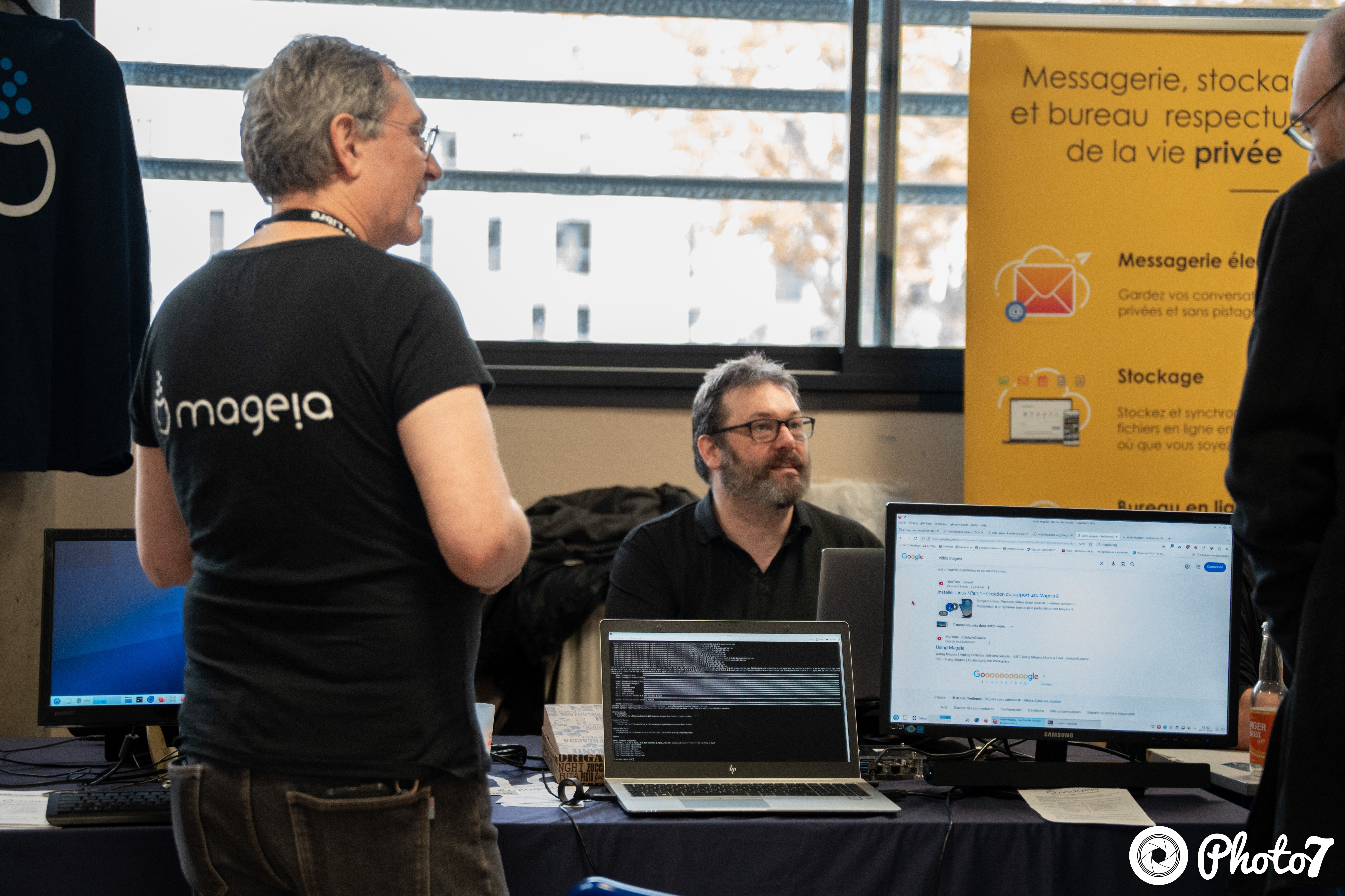 Exposant Mageia échangeant avec un visiteur au village associatif