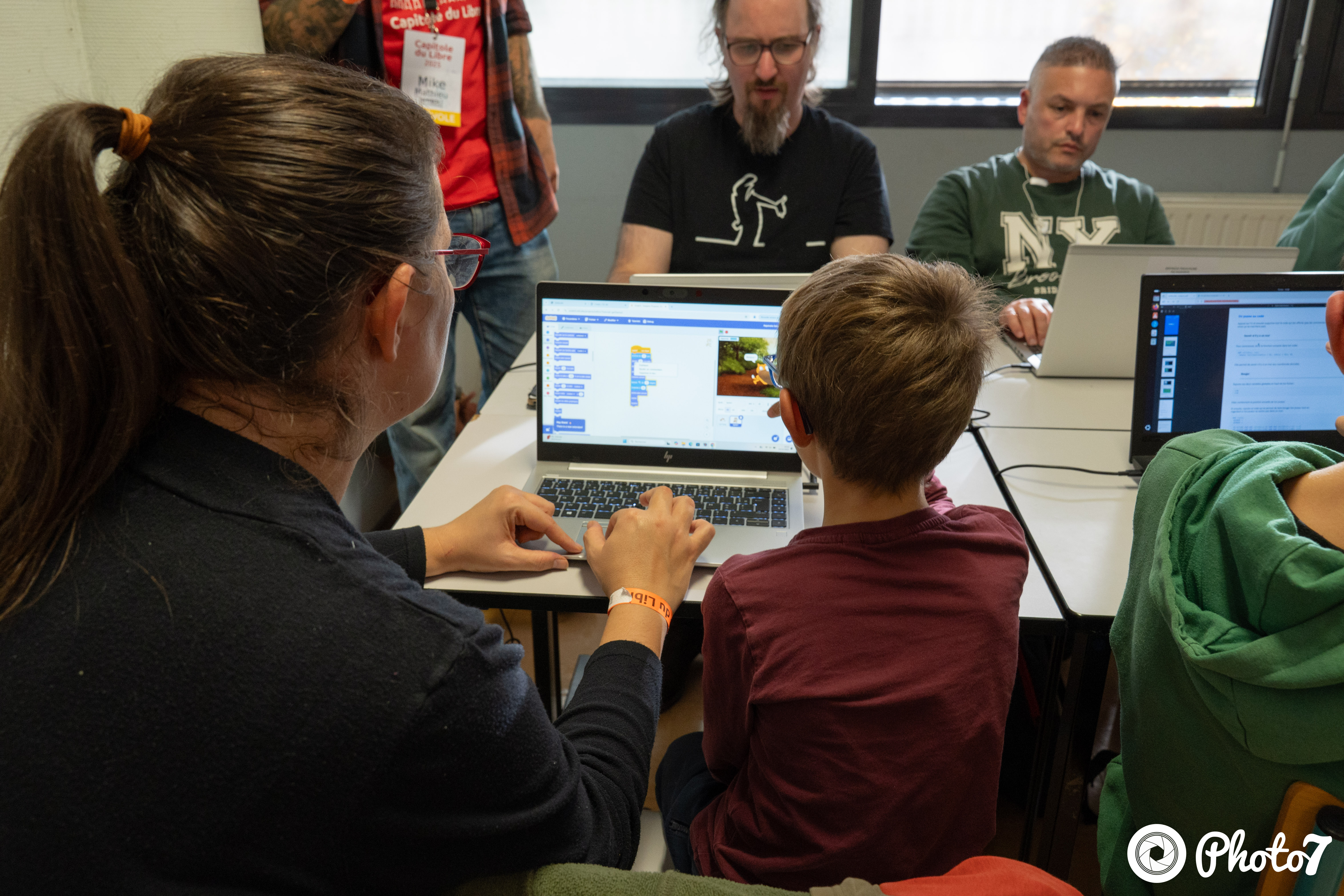 Enfants et adultes apprenant Scratch ensemble lors de l'atelier d'initiation au code