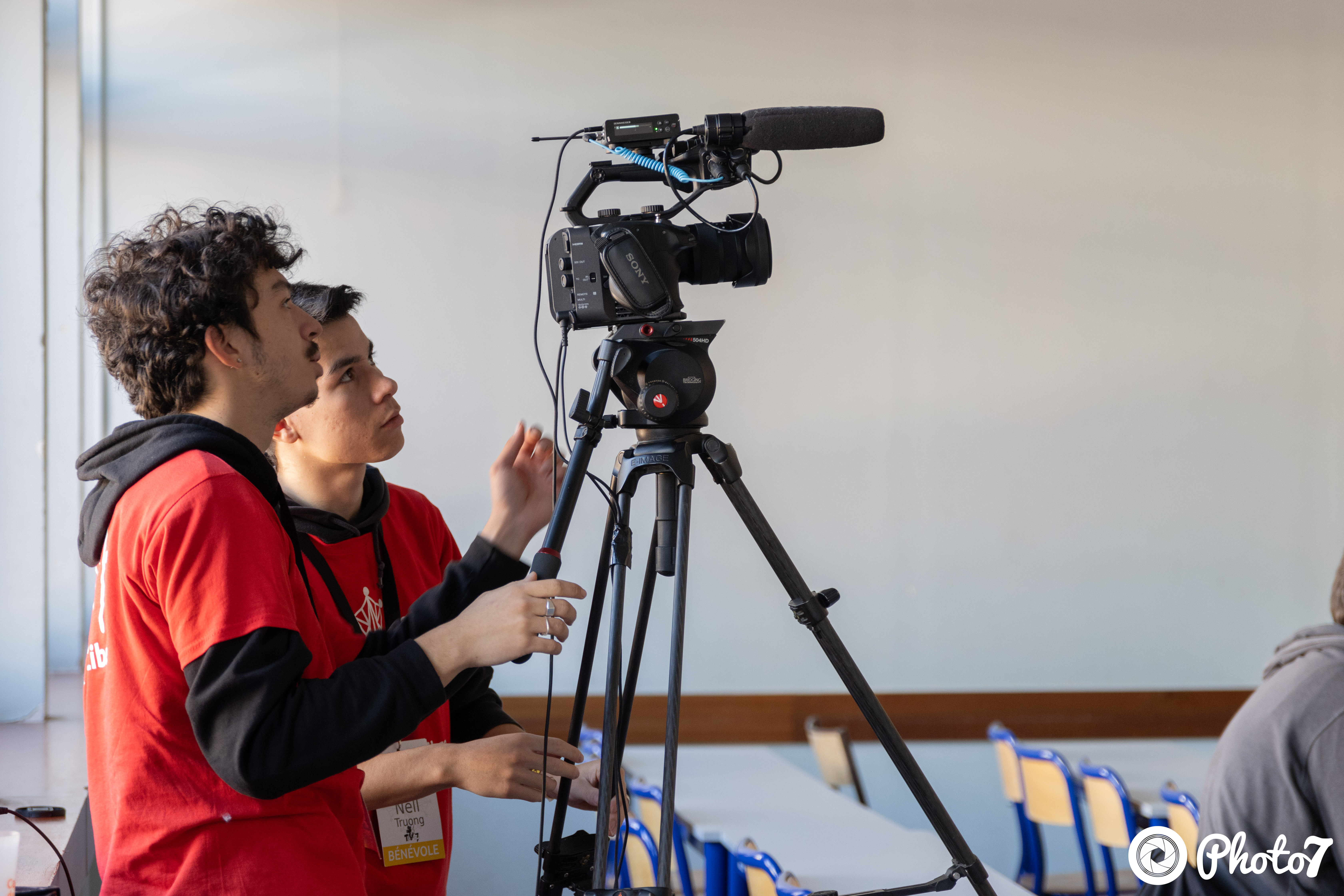 Deux bénévoles TVn7 installant une caméra sur trépied pour filmer une conférence
